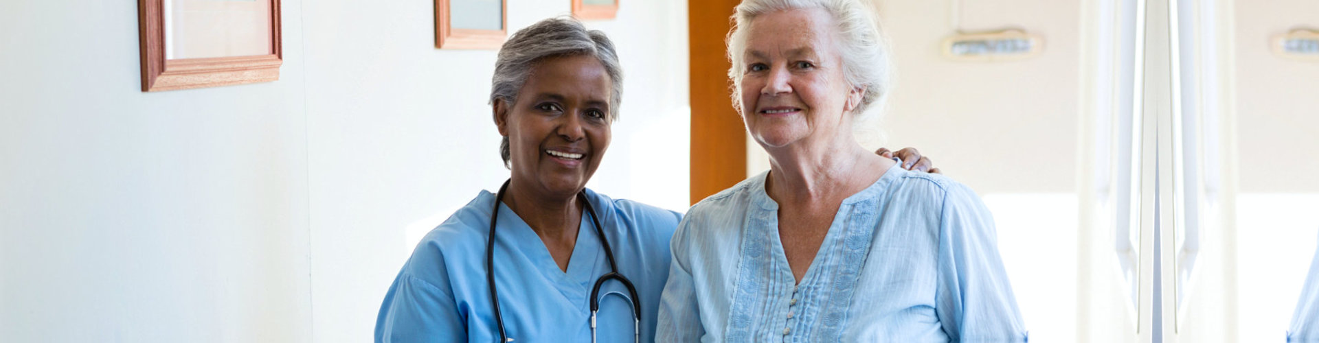 senior woman and nurse smiling each other